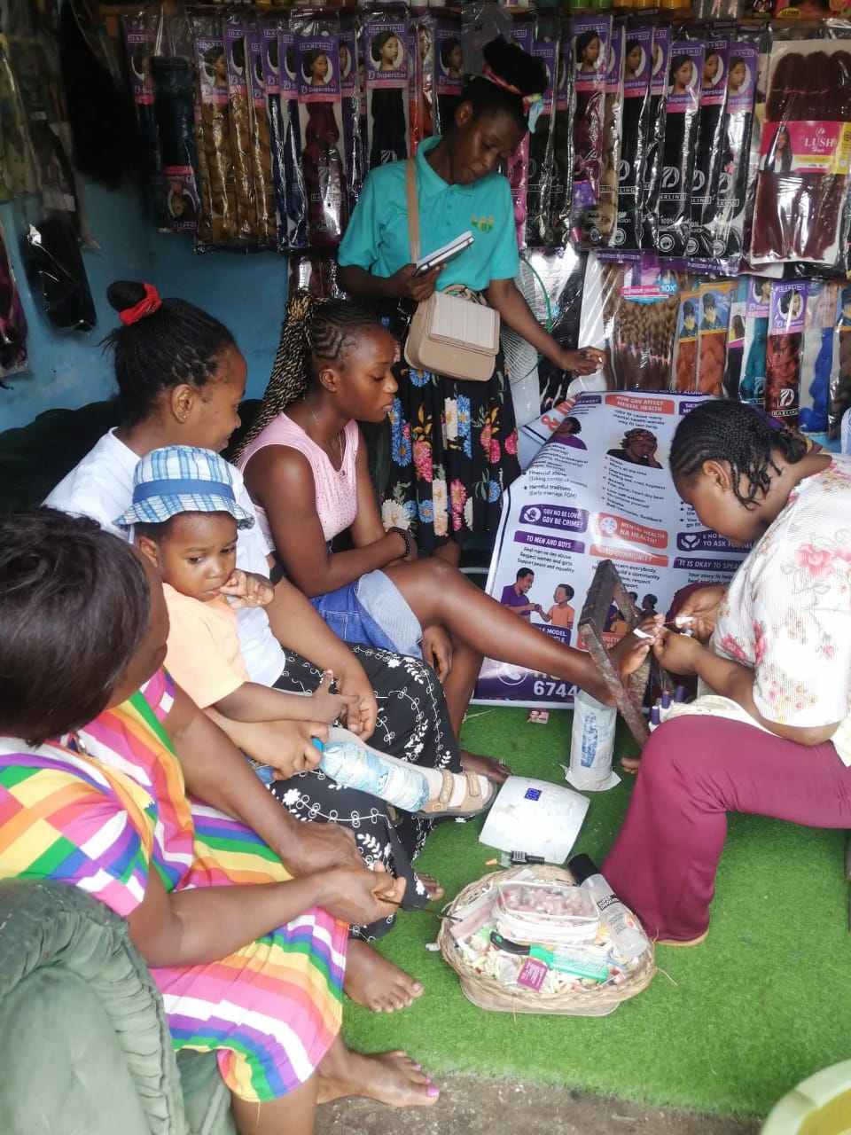 Women in a local salon listening to a Belosy Africa volunteer