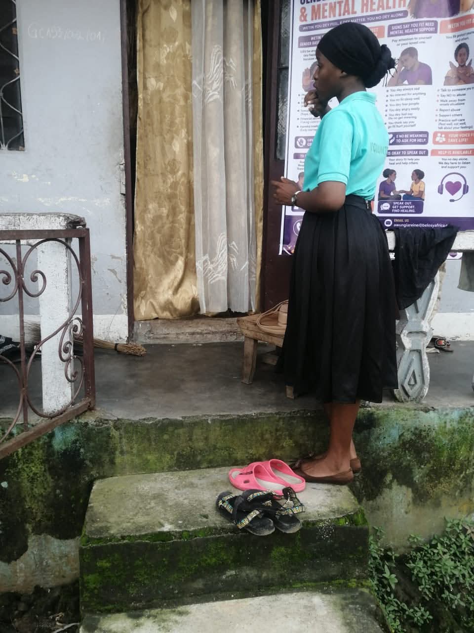 A Belosy Africa volunteer speaking with a woman at her doorstep